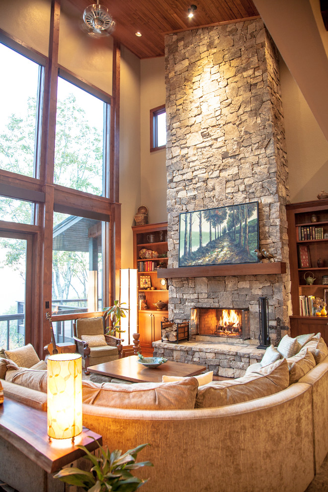 Inspiration for a large country open concept living room in Other with beige walls, dark hardwood floors, a standard fireplace, a stone fireplace surround, no tv and brown floor.