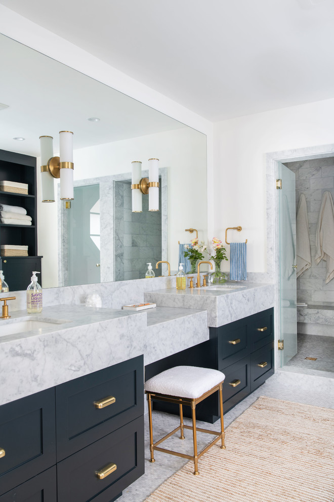 This is an example of a large transitional master bathroom in Los Angeles with shaker cabinets, black cabinets, white walls, marble floors, an undermount sink, marble benchtops, grey floor, a hinged shower door, white benchtops and an alcove shower.