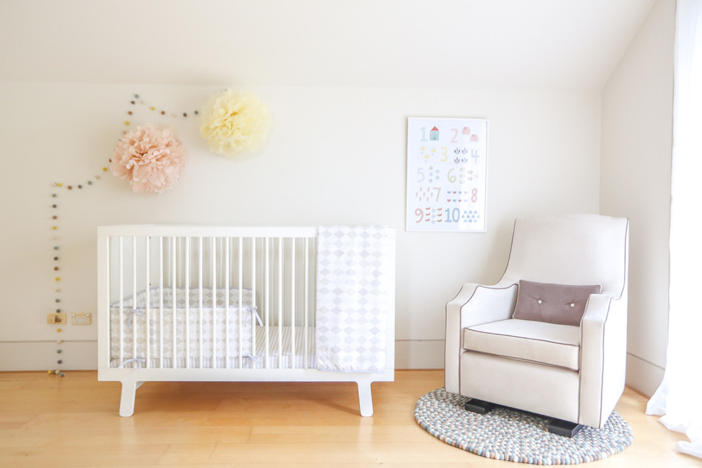 Mid-sized contemporary gender-neutral nursery in Sydney with white walls and light hardwood floors.