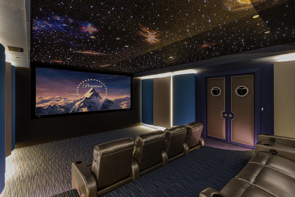 Photo of a large contemporary enclosed home theatre in New Orleans with blue walls, carpet, a projector screen and blue floor.