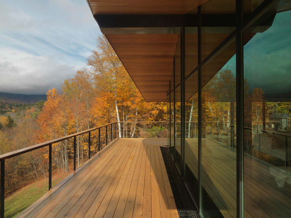 Inspiration for a large contemporary side yard deck in Burlington with a roof extension.