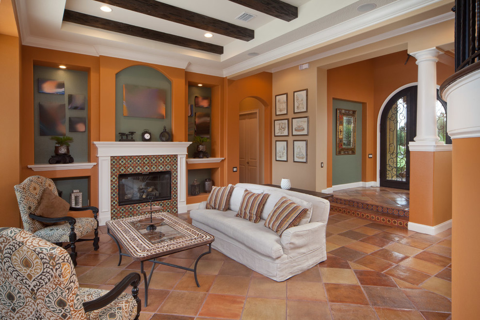 Large mediterranean formal open concept living room in Orlando with orange walls, terra-cotta floors, a standard fireplace, a tile fireplace surround and no tv.