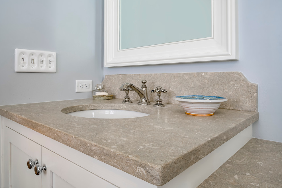 This is an example of a transitional master bathroom in Charleston with shaker cabinets, white cabinets, blue walls, an undermount sink and limestone benchtops.
