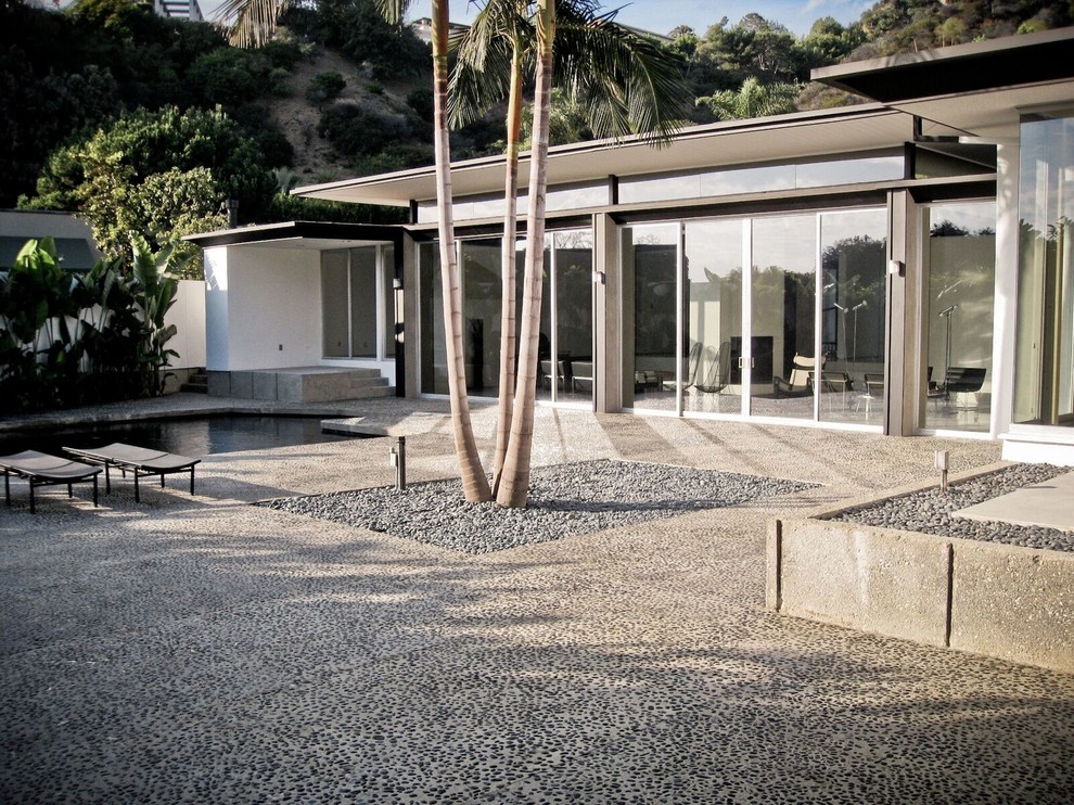 Large midcentury one-storey stucco white house exterior in Los Angeles with a flat roof.
