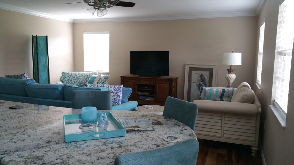 Photo of a mid-sized beach style open concept living room in Tampa with beige walls, medium hardwood floors, no fireplace and a freestanding tv.