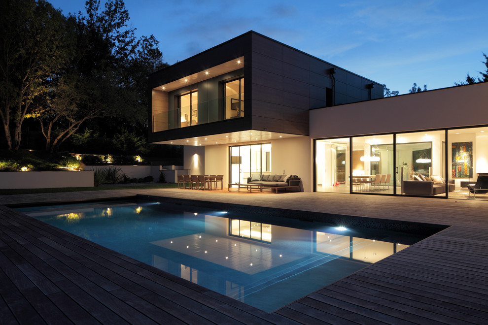 Contemporary backyard rectangular pool in Toulouse with decking.
