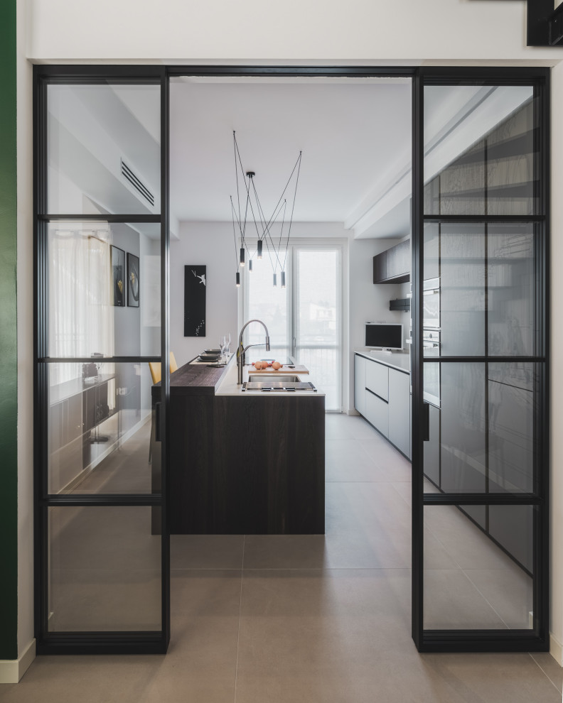 Inspiration for a mid-sized contemporary galley separate kitchen in Milan with an undermount sink, flat-panel cabinets, grey cabinets, solid surface benchtops, white splashback, stainless steel appliances, porcelain floors, with island, beige floor and white benchtop.