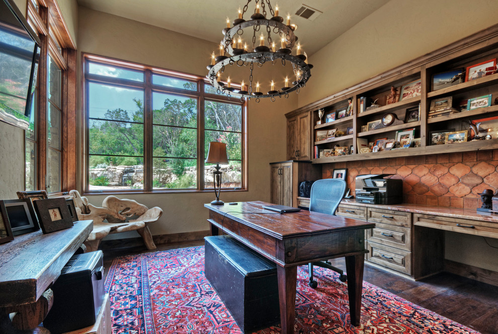 Photo of a country home office in Austin with beige walls, dark hardwood floors and a freestanding desk.