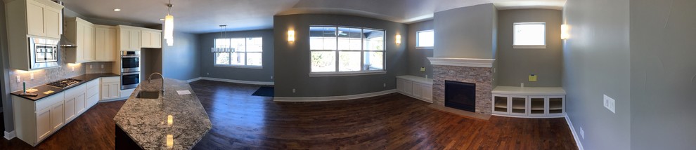 Inspiration for a transitional l-shaped medium tone wood floor open concept kitchen remodel in Denver with an undermount sink, recessed-panel cabinets, dark wood cabinets, granite countertops, beige backsplash, stone tile backsplash, stainless steel appliances and an island