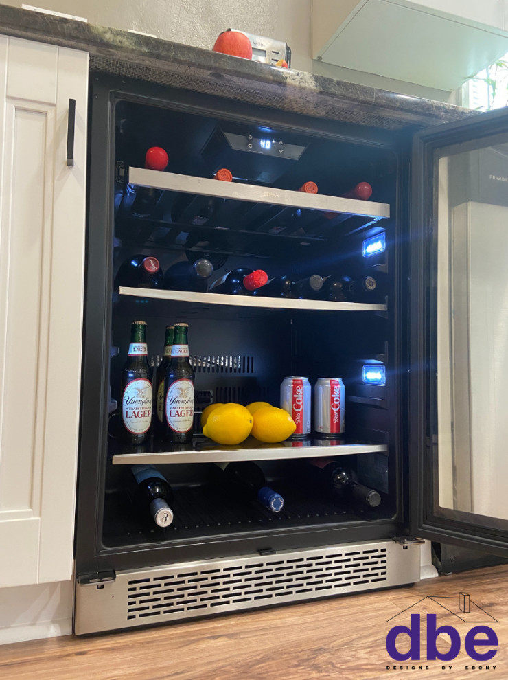 Example of a transitional galley laminate floor and brown floor eat-in kitchen design with an undermount sink, recessed-panel cabinets, white cabinets, granite countertops, stainless steel appliances and multicolored countertops