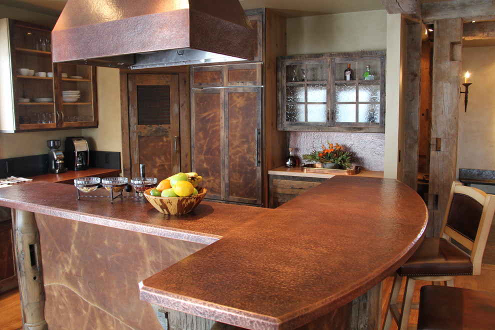 This is an example of a large country l-shaped eat-in kitchen in Other with shaker cabinets, distressed cabinets, copper benchtops, brown splashback, coloured appliances, medium hardwood floors, with island and brown floor.