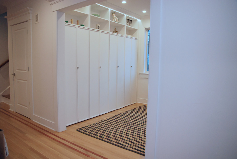 Inspiration for a small transitional mudroom in New York with white walls, light hardwood floors and coffered.