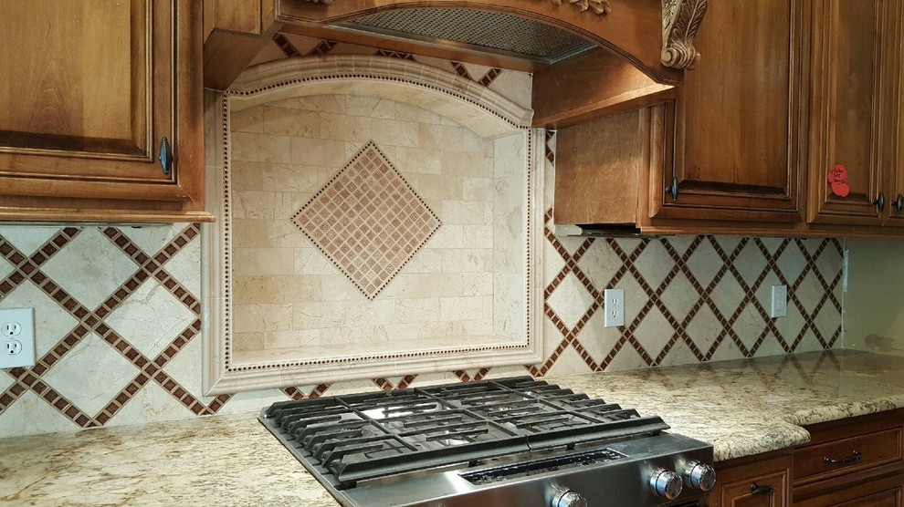 Kitchen - mid-sized traditional kitchen idea with medium tone wood cabinets, granite countertops, beige backsplash, terra-cotta backsplash and stainless steel appliances