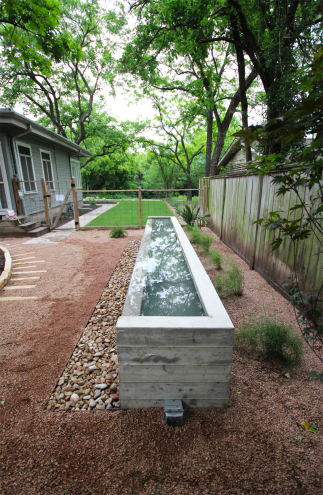 Halbschattiger, Mittelgroßer Klassischer Garten im Sommer, hinter dem Haus mit Wasserspiel, Granitsplitt und Holzzaun in Austin