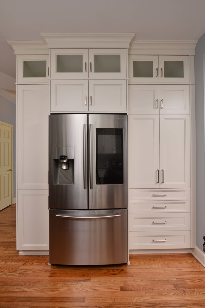 Eat-in kitchen - large transitional l-shaped eat-in kitchen idea with flat-panel cabinets, white cabinets, quartz countertops, stainless steel appliances and an island