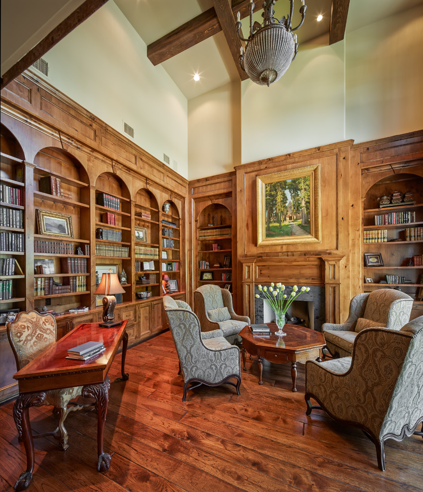 This is an example of a traditional study room in Houston with beige walls, dark hardwood floors, a standard fireplace and a freestanding desk.