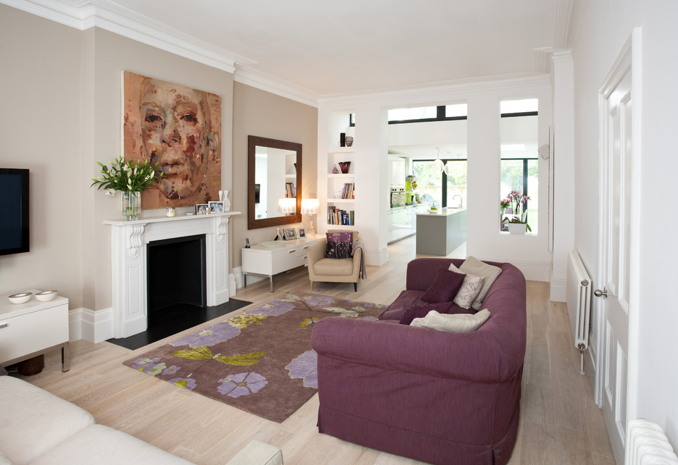 Photo of a mid-sized contemporary open concept living room in London with light hardwood floors and a standard fireplace.