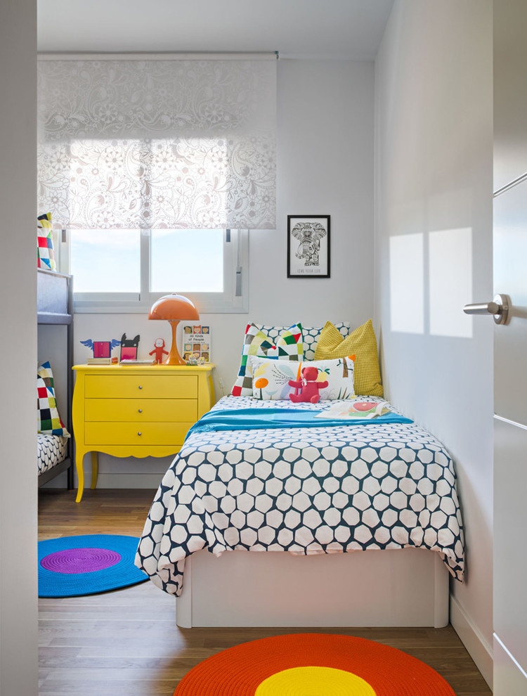This is an example of a small eclectic gender-neutral kids' bedroom for kids 4-10 years old in Malaga with white walls.