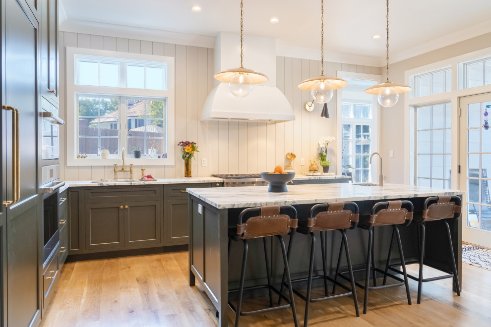 Foto på ett mellanstort vintage flerfärgad kök, med en enkel diskho, skåp i shakerstil, grå skåp, marmorbänkskiva, vitt stänkskydd, rostfria vitvaror, ljust trägolv, en köksö och brunt golv