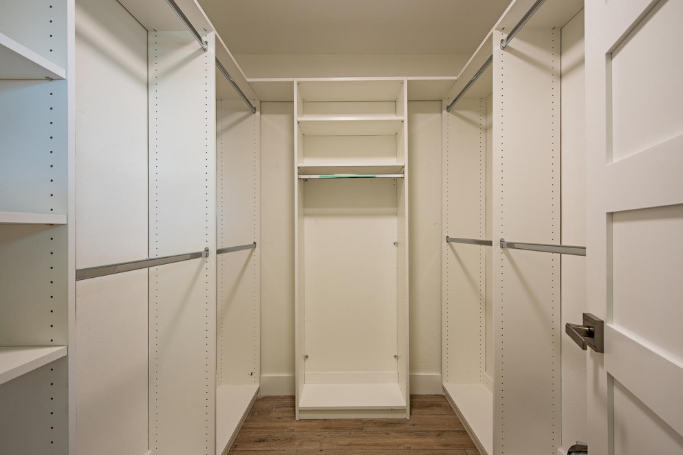 This is an example of a small beach style gender-neutral walk-in wardrobe in Other with shaker cabinets, white cabinets, ceramic floors and brown floor.
