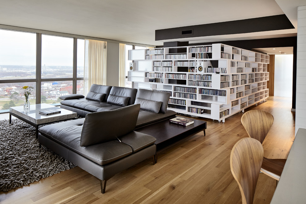 Large danish open concept light wood floor and brown floor living room library photo with beige walls, a tv stand and no fireplace
