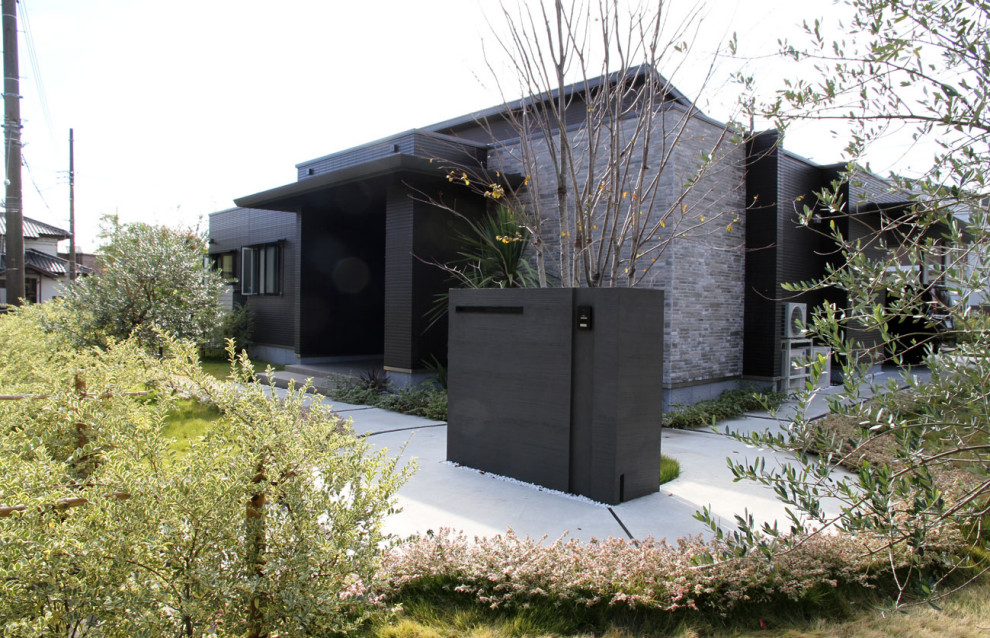 Idee per la villa ampia grigia moderna a un piano con rivestimento in pietra
