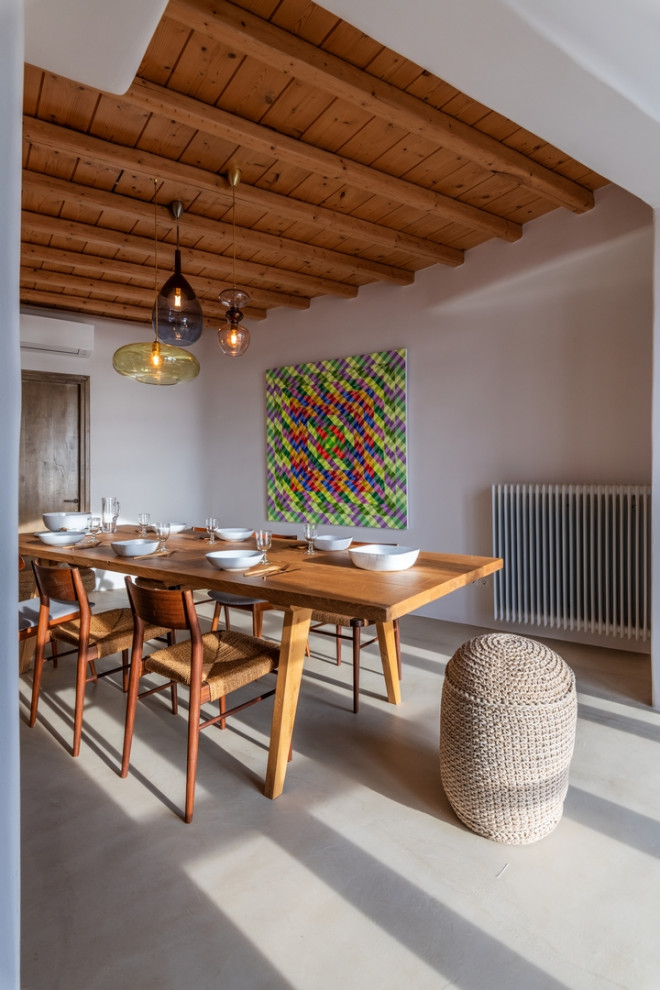 Inspiration for a mediterranean dining room in Other with white walls, concrete floors, grey floor, exposed beam and wood.