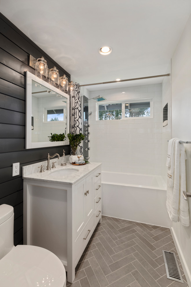 Photo of a mid-sized country master wet room bathroom in Seattle with shaker cabinets, white cabinets, a drop-in tub, a one-piece toilet, white tile, porcelain tile, white walls, porcelain floors, an undermount sink, engineered quartz benchtops, grey floor, white benchtops, a single vanity, a freestanding vanity and planked wall panelling.