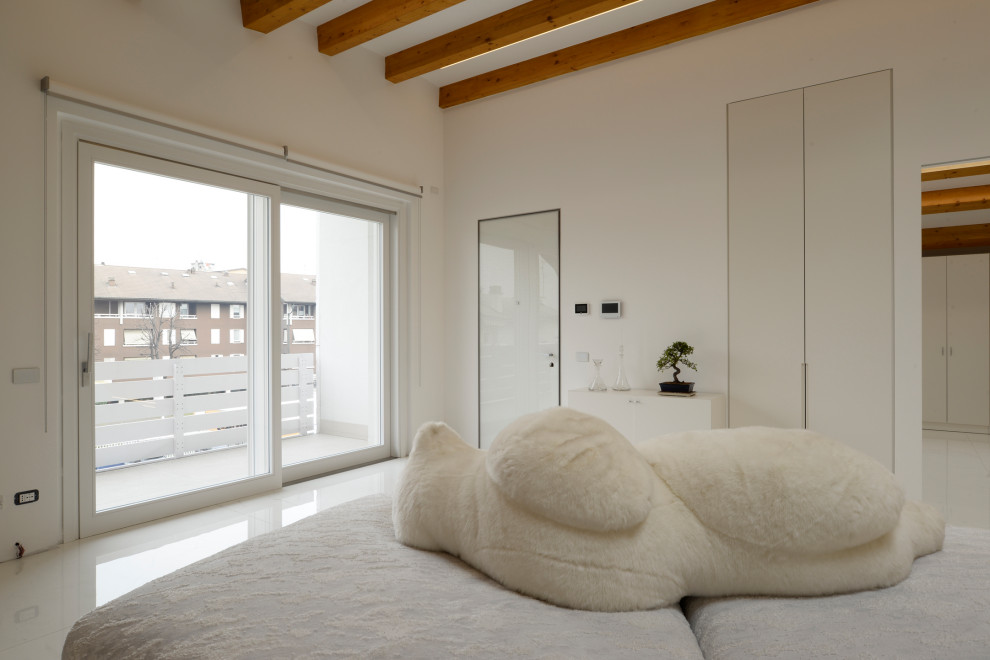 Photo of a modern kids' room in Milan with white walls, white floor and exposed beam.