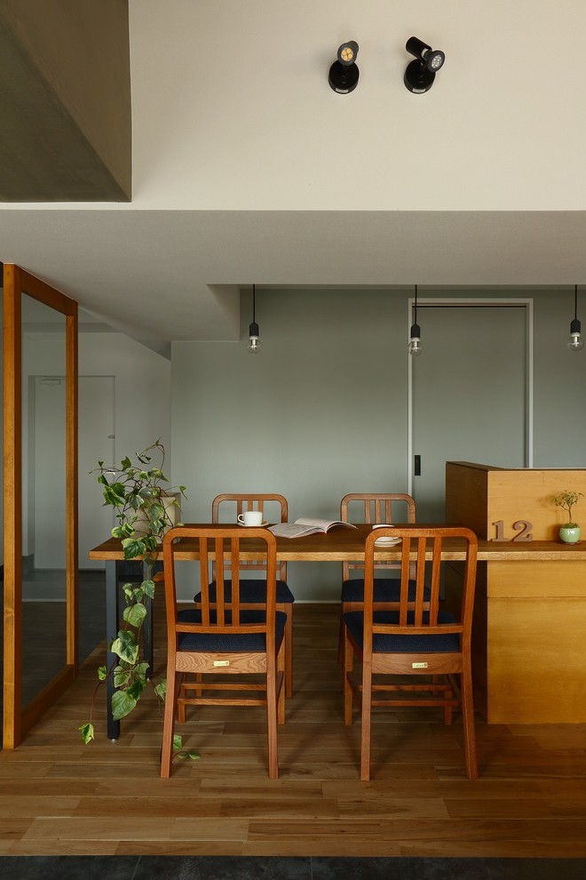 Photo of a mid-sized midcentury open plan dining in Kyoto with white walls, ceramic floors and grey floor.