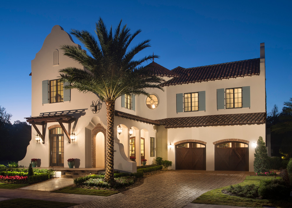 Photo of a large mediterranean three-storey beige exterior in Orlando with mixed siding.