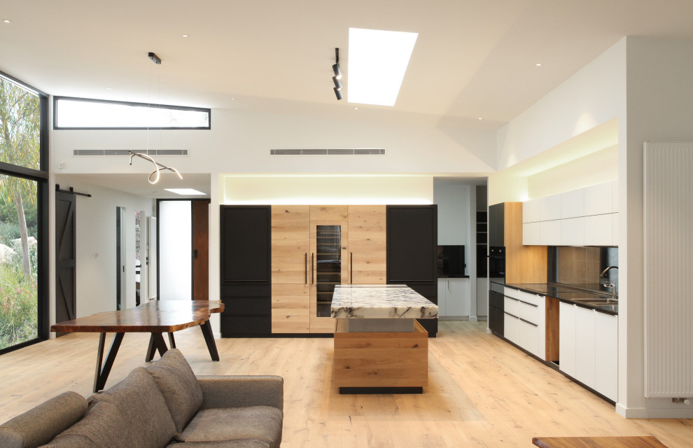 Großes, Offenes Wohnzimmer mit weißer Wandfarbe, hellem Holzboden, Kamin, Kaminumrandung aus Holz, TV-Wand und braunem Boden in Melbourne