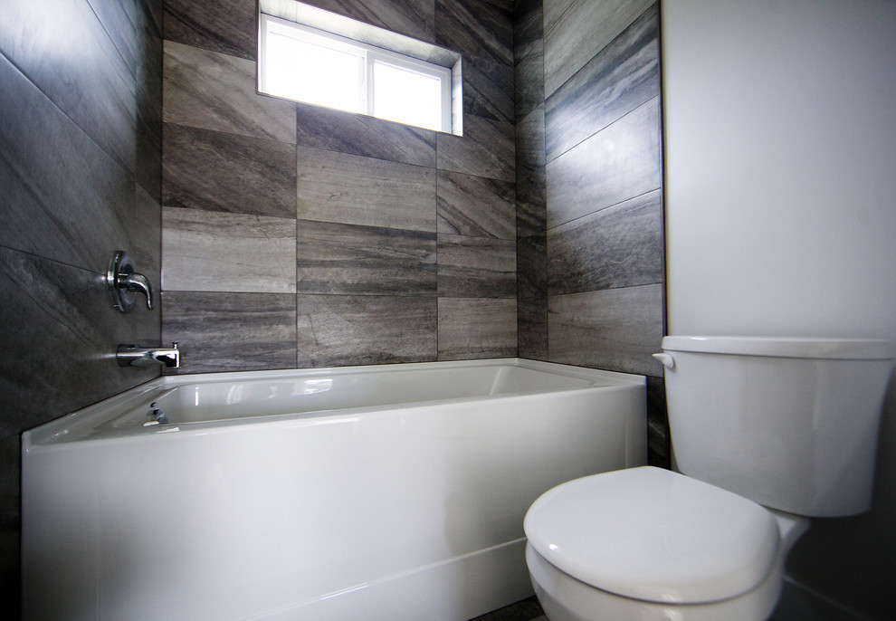 Design ideas for a modern kids bathroom in Vancouver with an undermount sink, shaker cabinets, white cabinets, quartzite benchtops, a drop-in tub, a shower/bathtub combo, a two-piece toilet, gray tile, ceramic tile, white walls and ceramic floors.