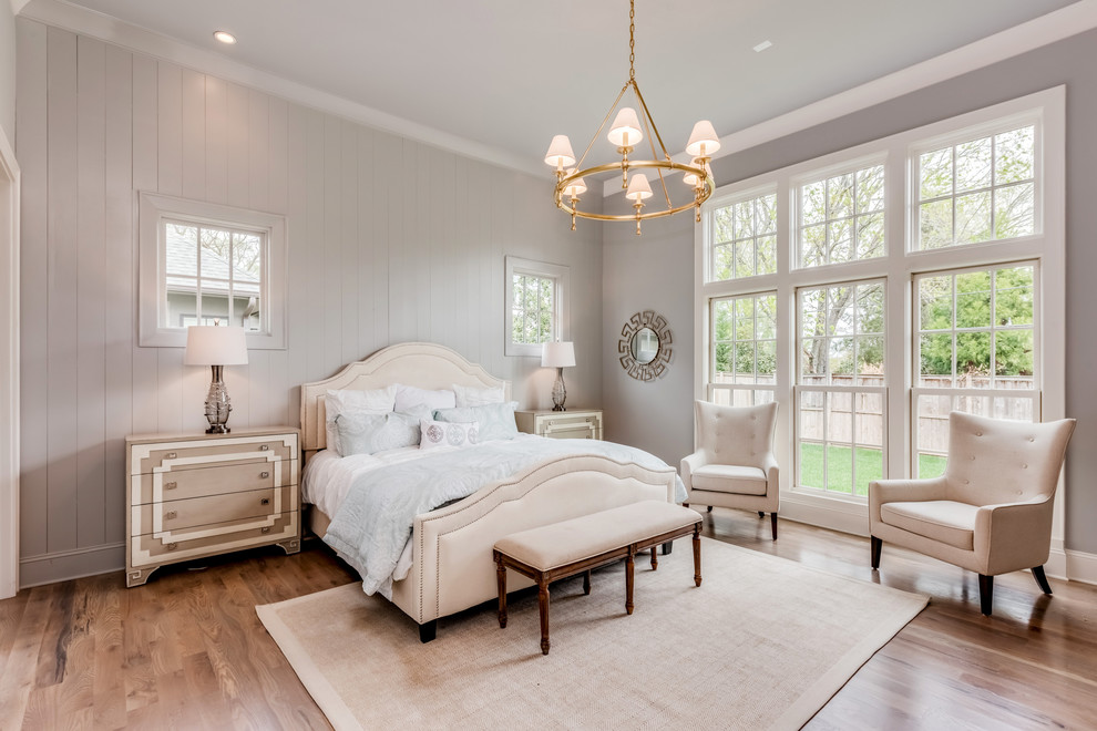 This is an example of a country master bedroom in Other with grey walls, light hardwood floors and beige floor.