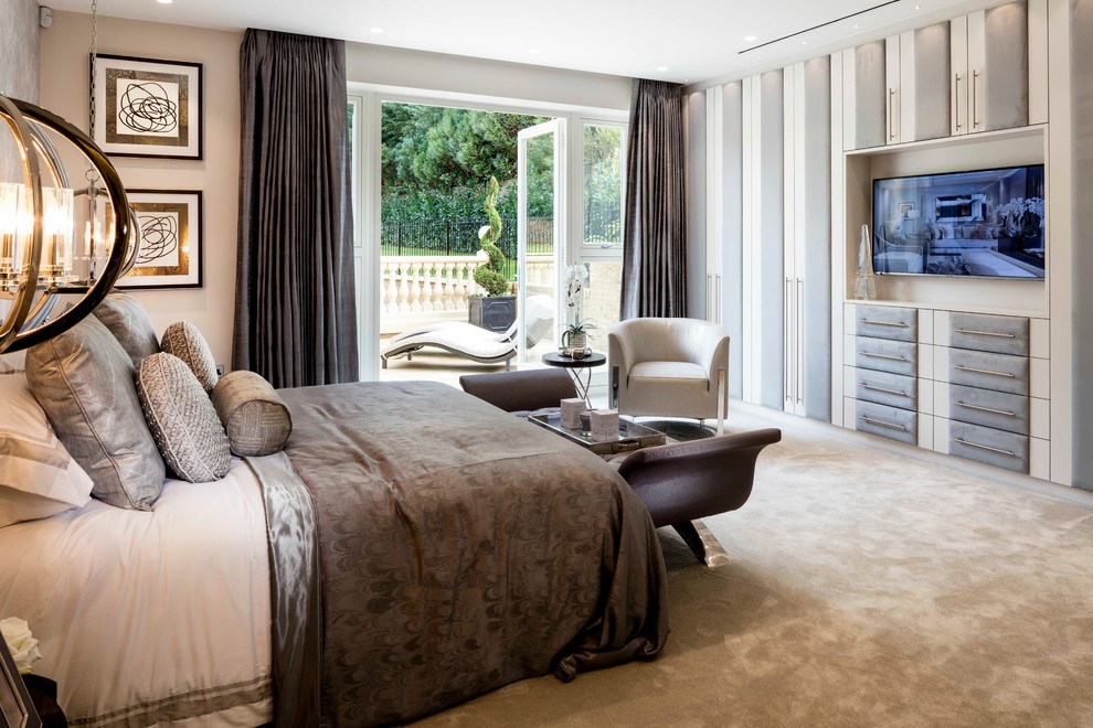 Transitional master bedroom in London with beige walls and carpet.