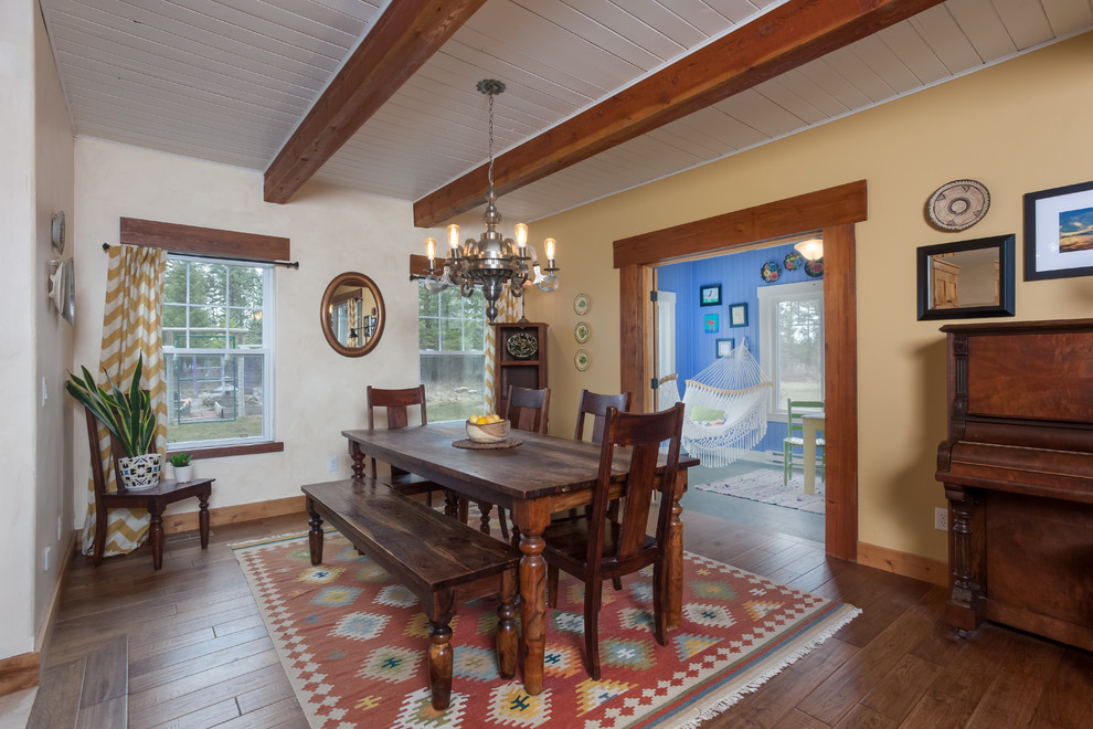 Idée de décoration pour une salle à manger ouverte sur le salon sud-ouest américain de taille moyenne avec un mur jaune, un sol en bois brun et un sol marron.