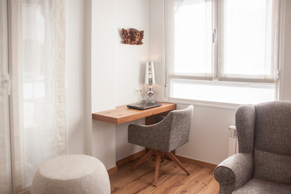 Foto de sótano actual de tamaño medio con paredes grises y suelo de madera en tonos medios