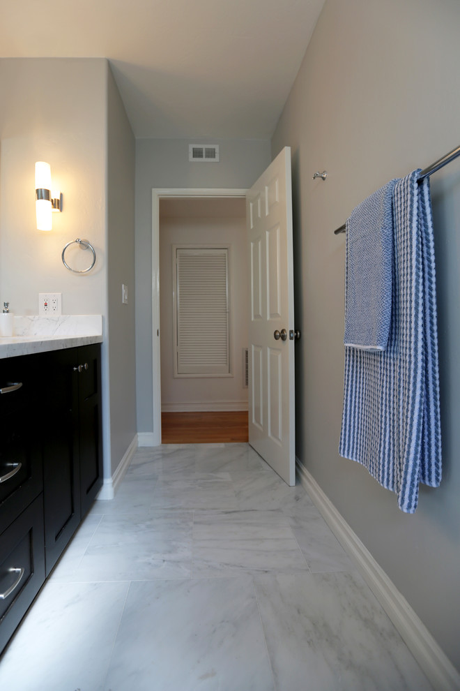 Photo of a large traditional kids bathroom in San Diego with shaker cabinets, black cabinets, marble benchtops, blue tile, stone tile, an alcove tub, a shower/bathtub combo, a two-piece toilet, an undermount sink, white walls and marble floors.