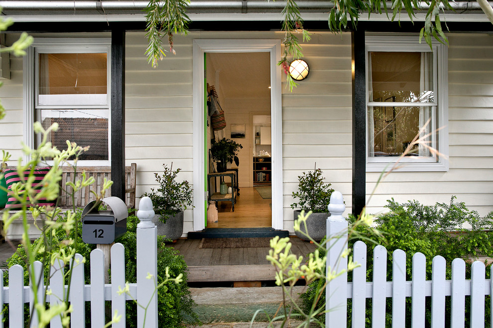 Traditional front door in Sydney with white walls, medium hardwood floors, a single front door and brown floor.