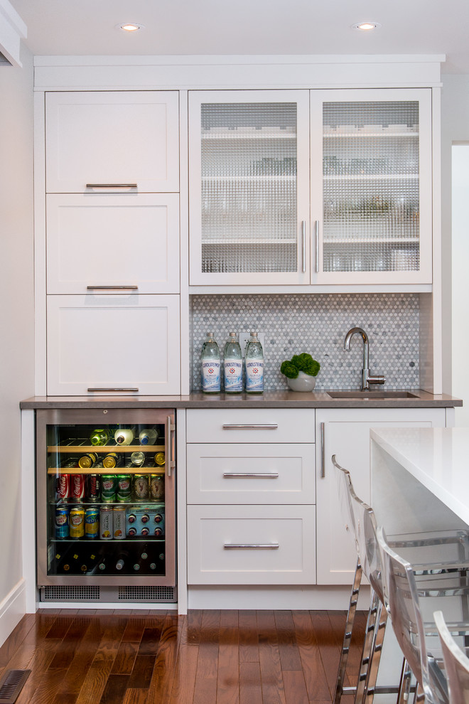 Large transitional l-shaped medium tone wood floor eat-in kitchen photo in Calgary with an undermount sink, shaker cabinets, quartz countertops, multicolored backsplash, mosaic tile backsplash, stainless steel appliances, an island and white cabinets