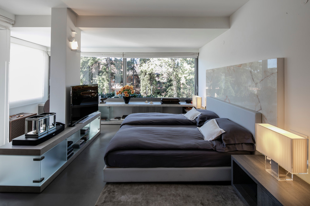 This is an example of a mid-sized contemporary master bedroom in Rome with white walls and grey floor.
