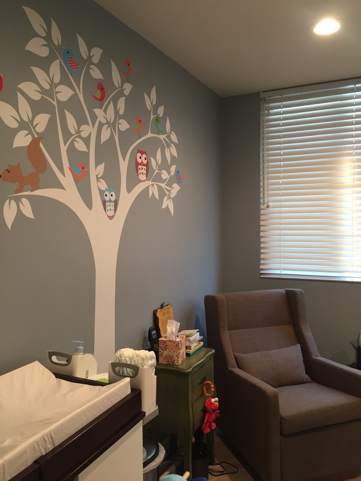 This is an example of a mid-sized contemporary nursery for boys in Los Angeles with blue walls and carpet.