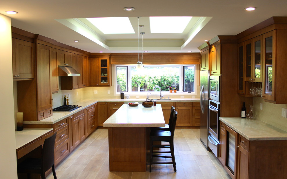 This is an example of a mid-sized modern u-shaped separate kitchen in San Francisco with an undermount sink, recessed-panel cabinets, medium wood cabinets, quartz benchtops, beige splashback, travertine splashback, stainless steel appliances, ceramic floors and with island.