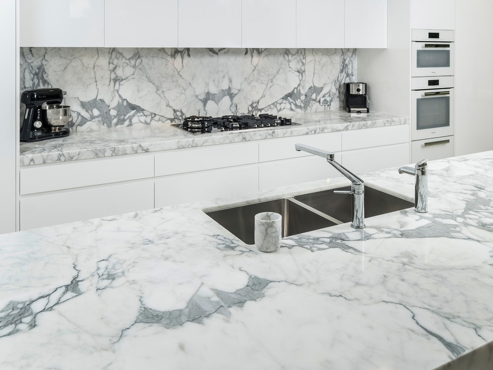Design ideas for a large modern open plan kitchen in Sydney with an undermount sink, white cabinets, marble benchtops, stone slab splashback, stainless steel appliances and with island.