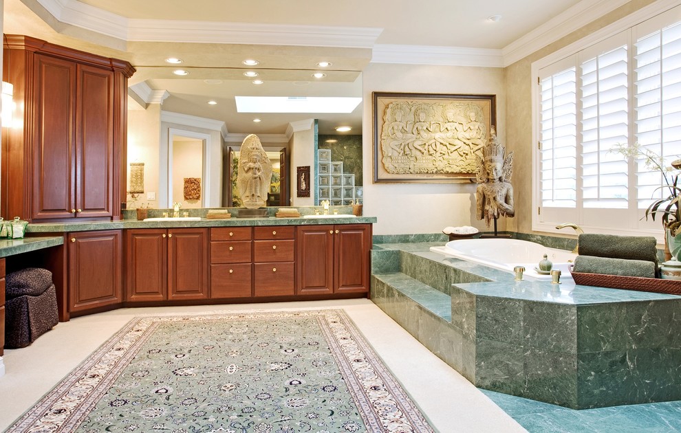 This is an example of an asian master bathroom in Toronto with raised-panel cabinets, medium wood cabinets, a drop-in tub, beige walls, a drop-in sink, beige floor and green benchtops.