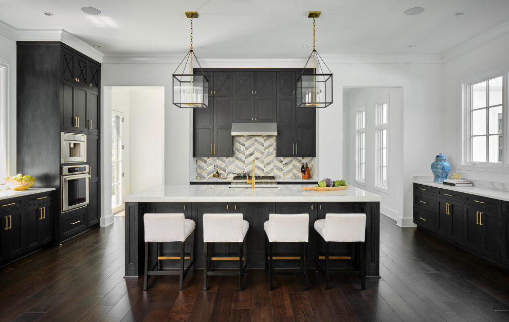 This is an example of an expansive open plan kitchen with an undermount sink, recessed-panel cabinets, black cabinets, stainless steel appliances, dark hardwood floors, with island and white benchtop.