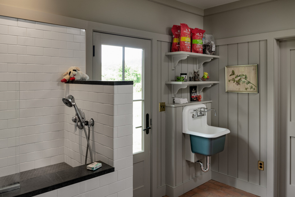 Design ideas for a country laundry room in New York with an utility sink, grey walls, medium hardwood floors, brown floor and panelled walls.