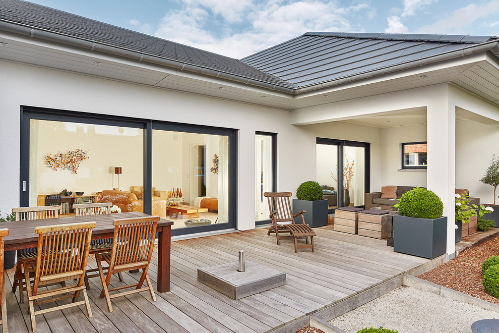 Überdachte, Große Landhausstil Terrasse hinter dem Haus mit Kübelpflanzen in Nürnberg