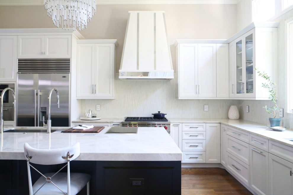 Huge transitional medium tone wood floor and brown floor eat-in kitchen photo with an undermount sink, recessed-panel cabinets, white cabinets, quartzite countertops, white backsplash, ceramic backsplash, stainless steel appliances, an island and white countertops