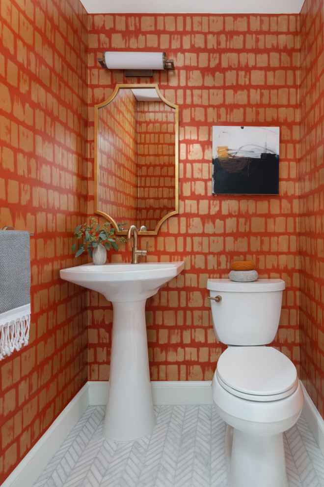 This is an example of a transitional powder room in DC Metro with porcelain tile, orange walls, marble floors and wallpaper.